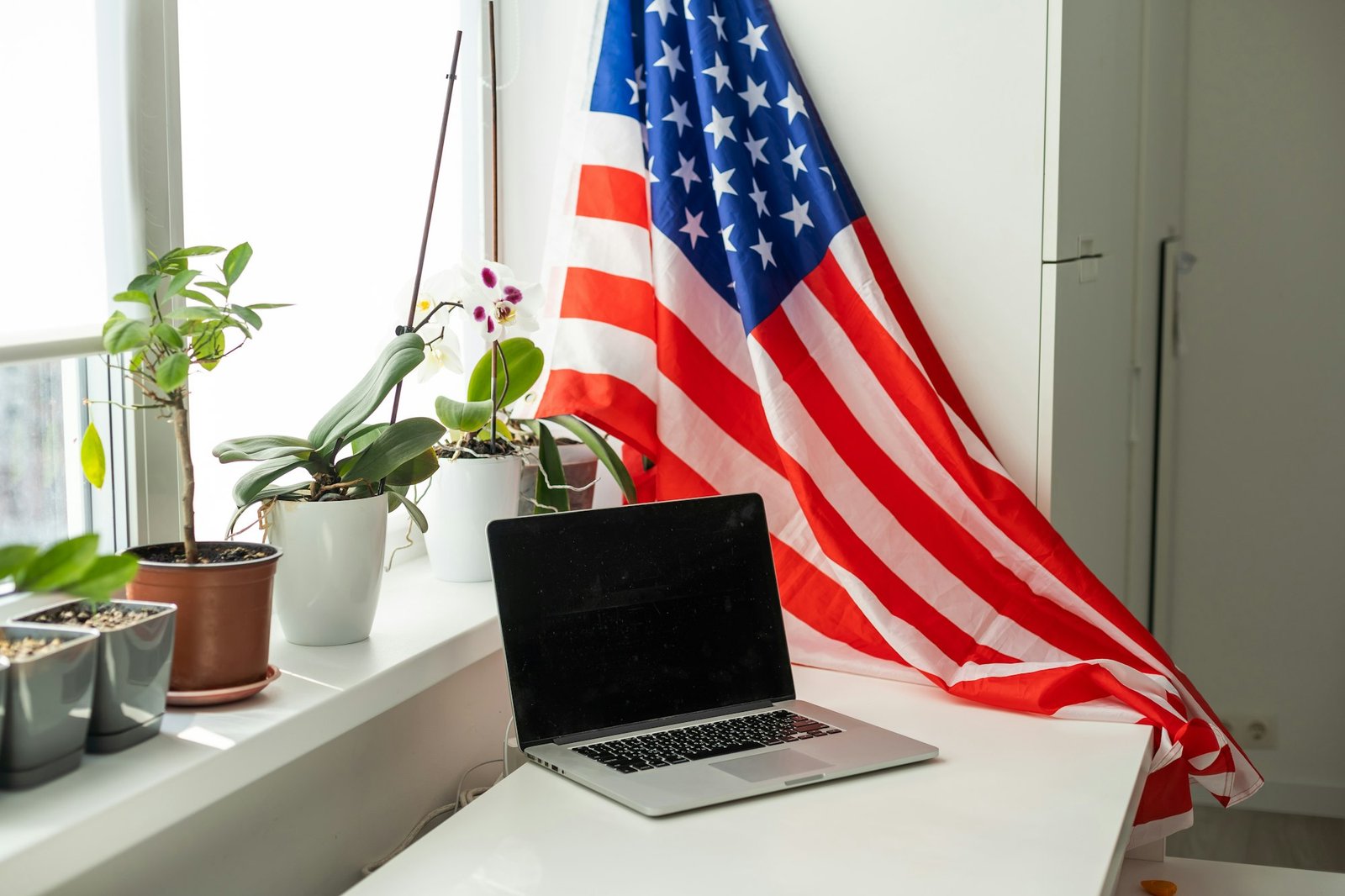 US flag and laptop on white background with copy space